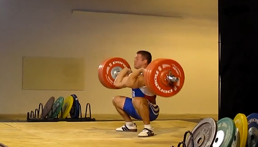 A man performs a squat clean.